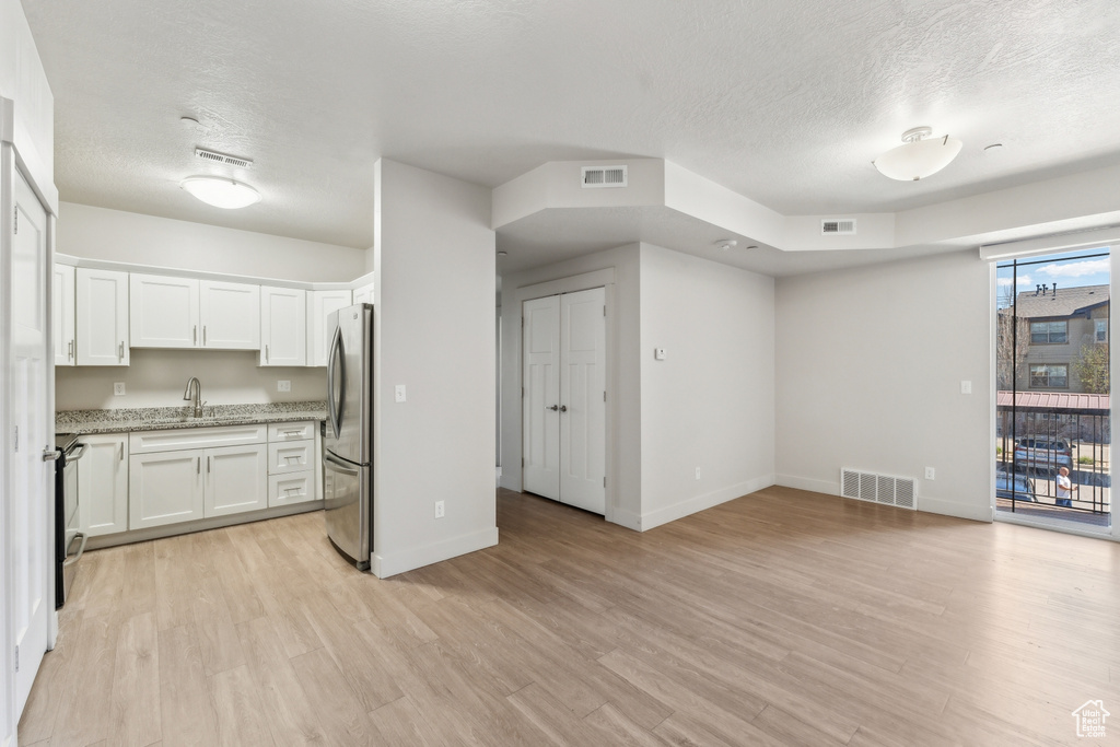 Interior space featuring a sink, visible vents, and a textured ceiling