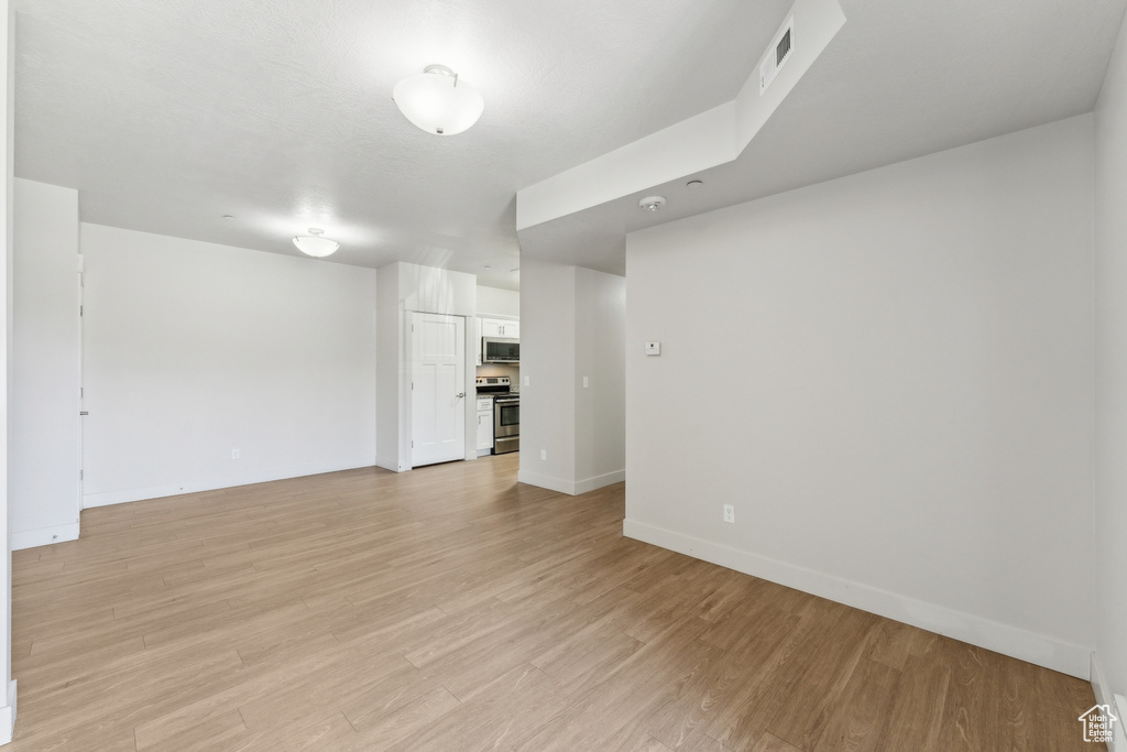 Interior space featuring baseboards, light wood-style flooring, and visible vents