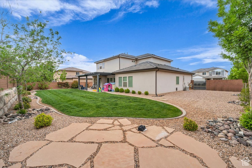 Back of house with a yard, a patio, stucco siding, and a fenced backyard