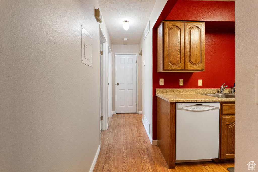 Hallway with light wood-style floors, baseboards, and a sink
