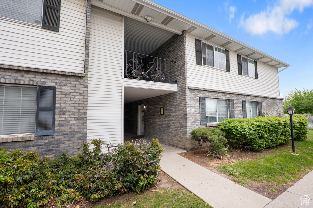 Exterior space featuring brick siding and a balcony