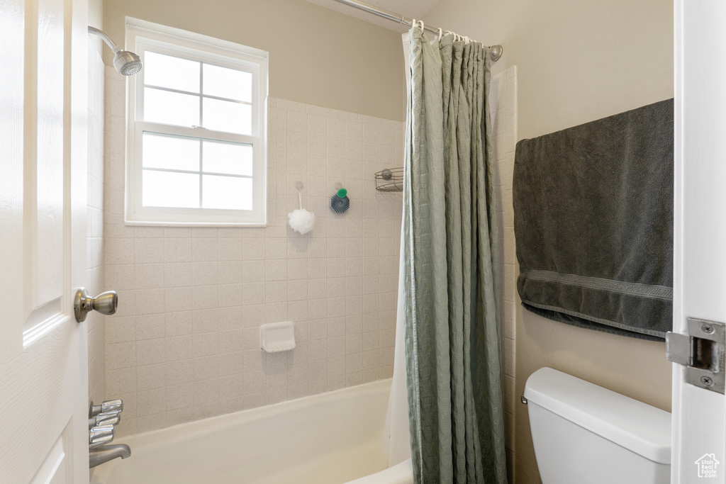 Full bath with shower / bath combination with curtain and toilet