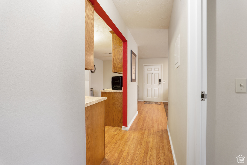 Hallway with light wood finished floors and baseboards