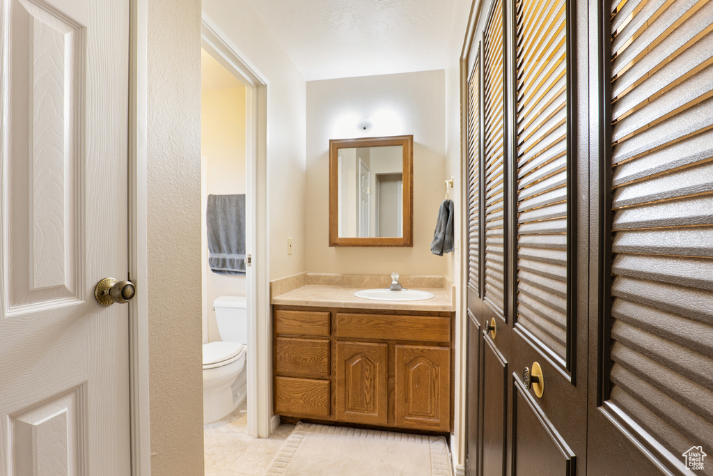 Bathroom featuring tile patterned floors, toilet, and vanity