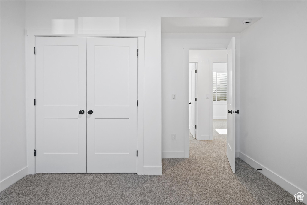 Unfurnished bedroom with carpet flooring, baseboards, and a closet