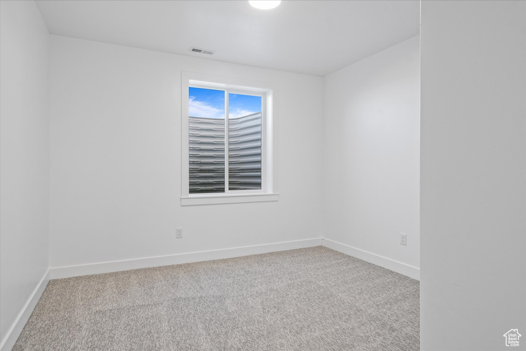 Empty room with baseboards, carpet flooring, and visible vents