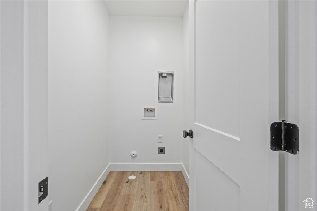 Washroom featuring laundry area, hookup for an electric dryer, baseboards, hookup for a washing machine, and light wood-style floors