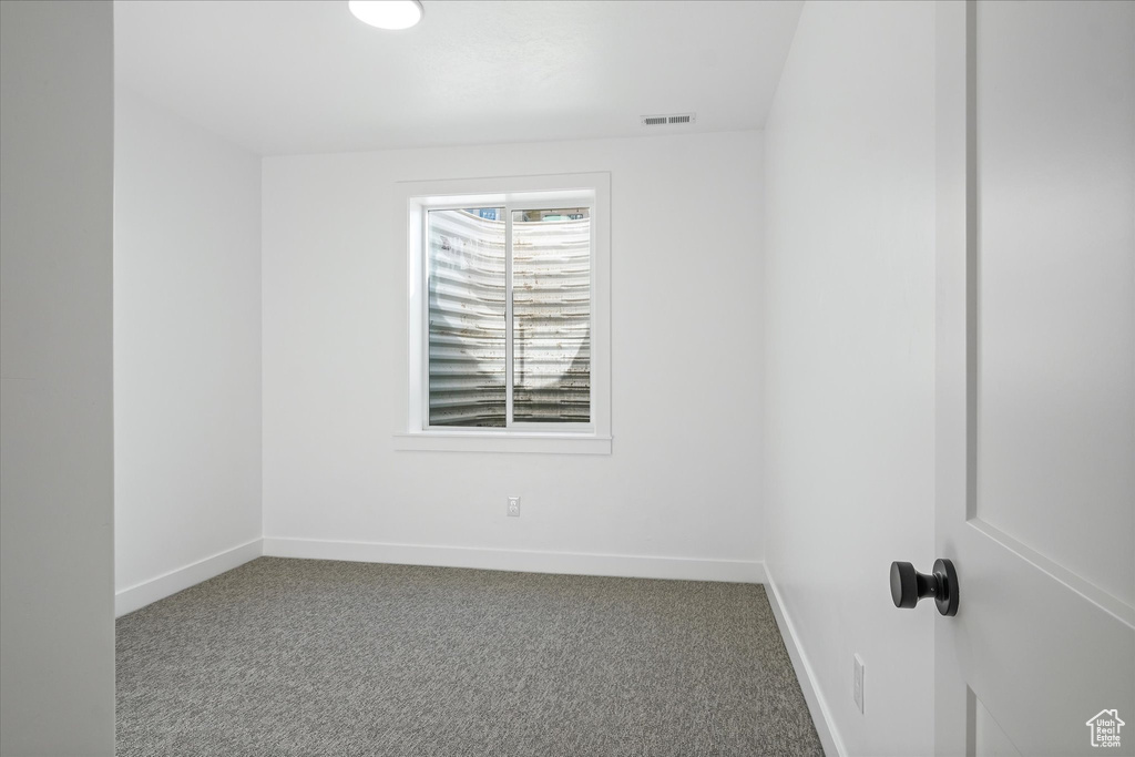 Unfurnished room with baseboards, visible vents, and carpet floors