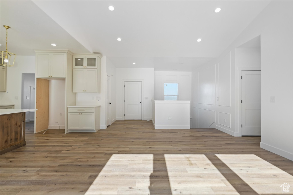 Unfurnished room with baseboards, light wood-style flooring, lofted ceiling, and recessed lighting