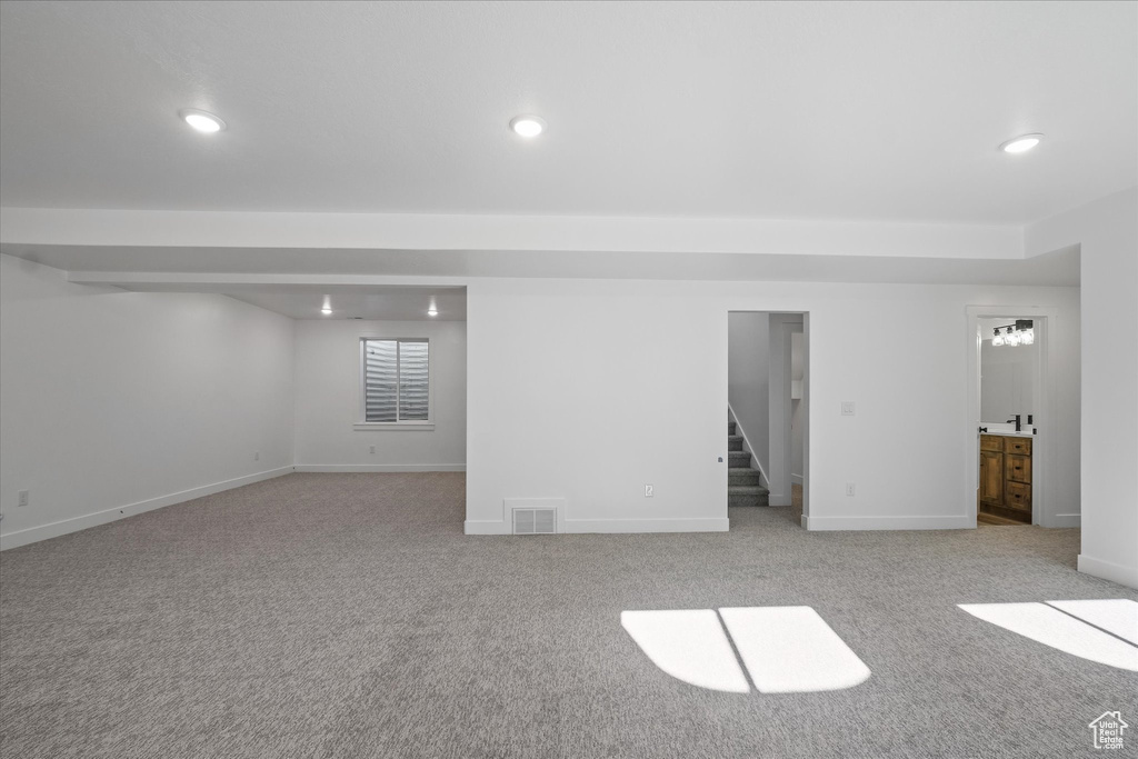 Basement featuring stairway, light colored carpet, visible vents, and recessed lighting