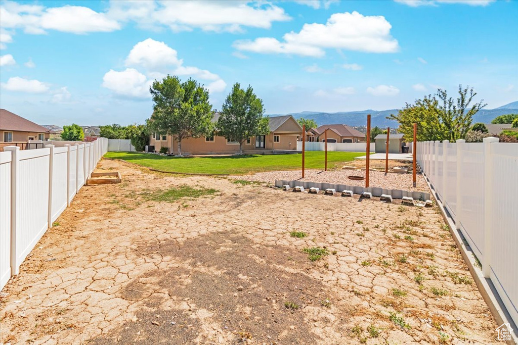 View of yard with a fenced backyard, a mountain view, and a residential view