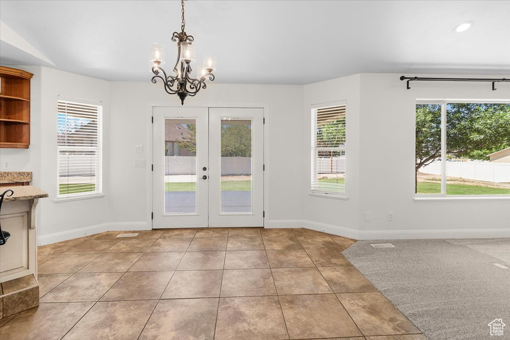 Entryway with baseboards, a notable chandelier, french doors, and tile patterned flooring