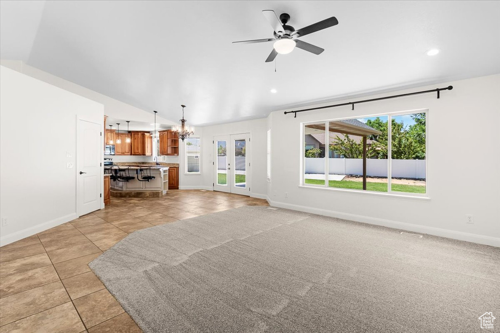 Unfurnished living room featuring light tile patterned floors, baseboards, and plenty of natural light