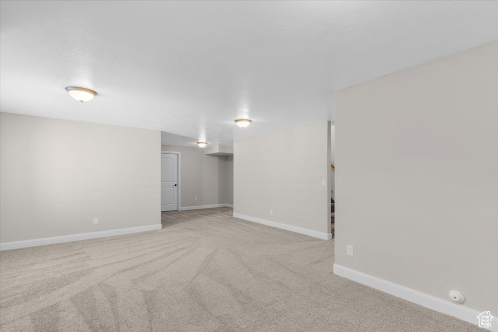 Finished below grade area featuring baseboards and carpet