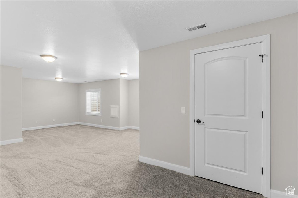 Carpeted spare room with baseboards and visible vents