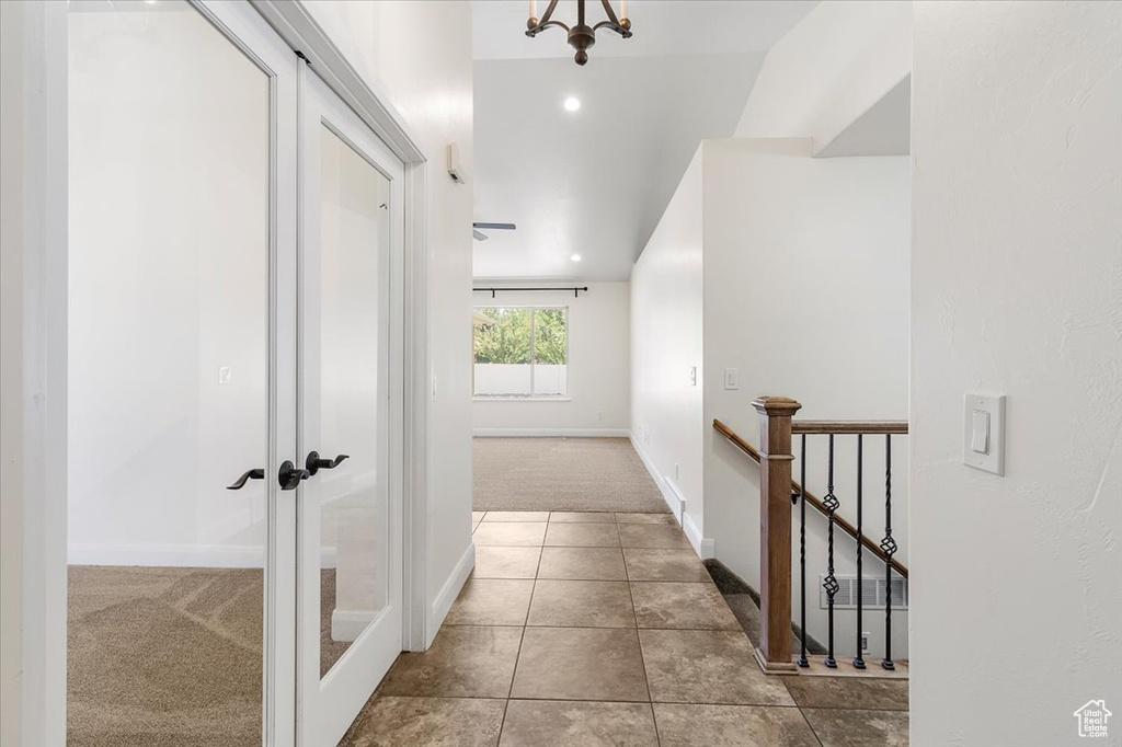 Corridor featuring french doors, an upstairs landing, tile patterned flooring, carpet floors, and baseboards
