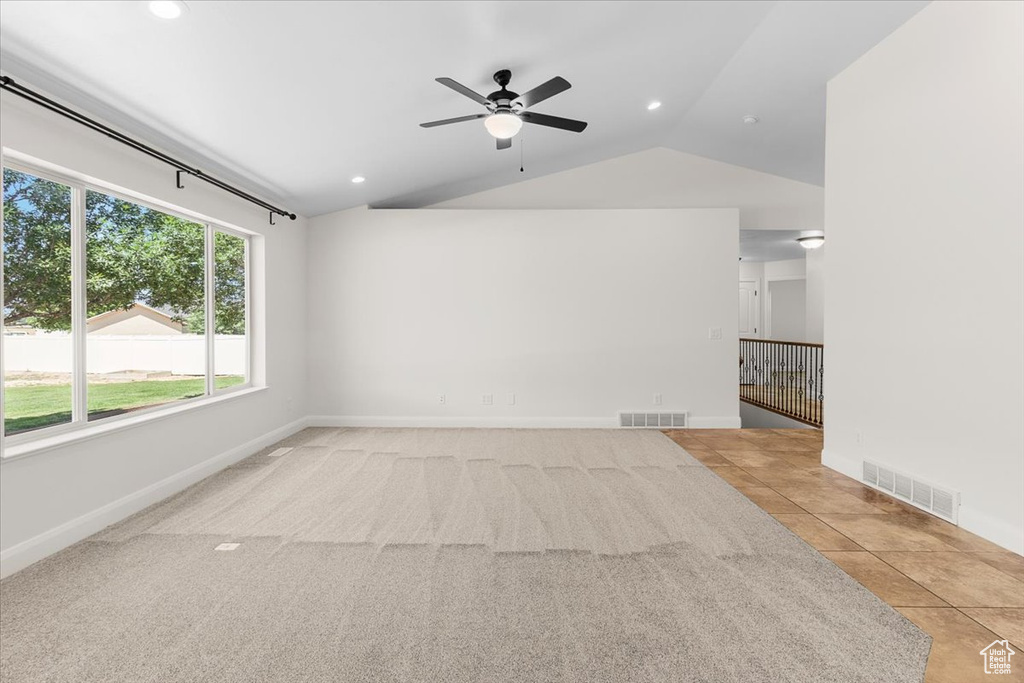 Unfurnished living room with visible vents, baseboards, lofted ceiling, and ceiling fan
