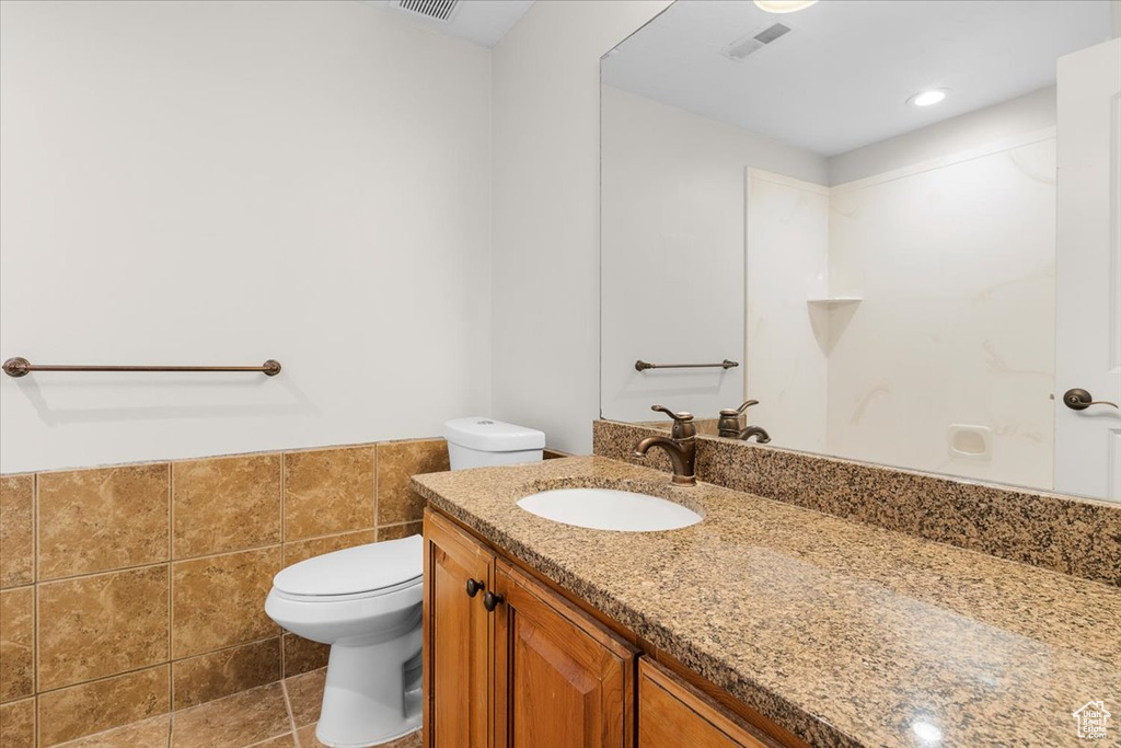 Bathroom featuring a wainscoted wall, toilet, visible vents, and vanity