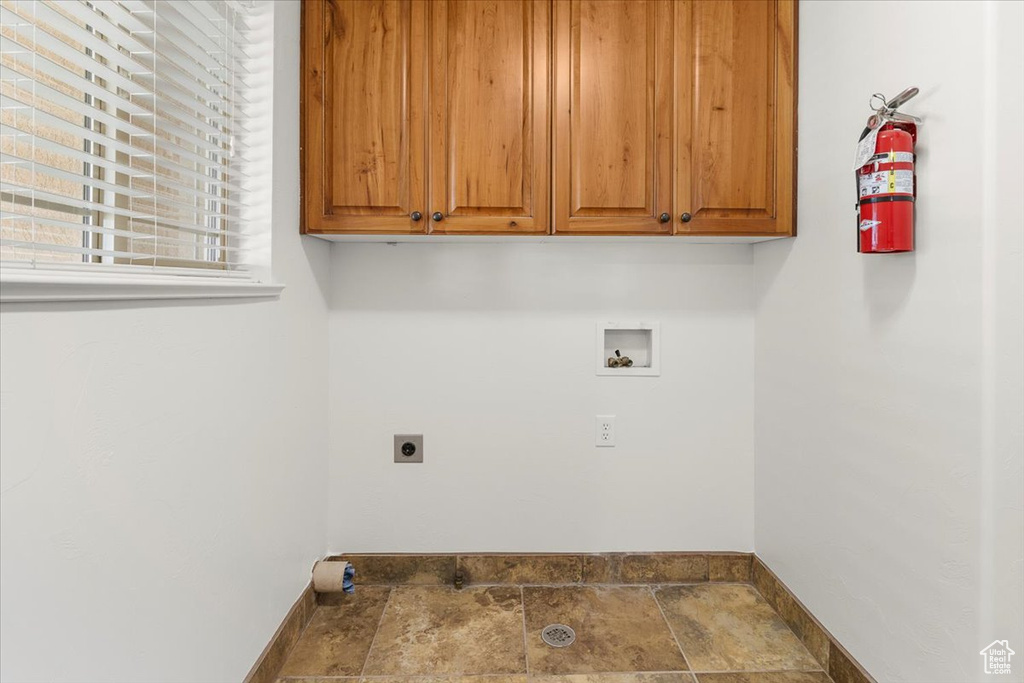 Laundry room featuring cabinet space, baseboards, hookup for a washing machine, and electric dryer hookup