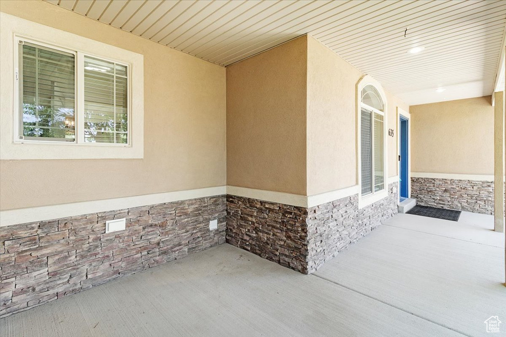 Exterior space featuring stone siding and stucco siding