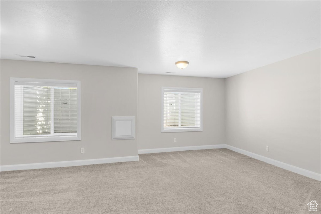 Empty room featuring light carpet and baseboards