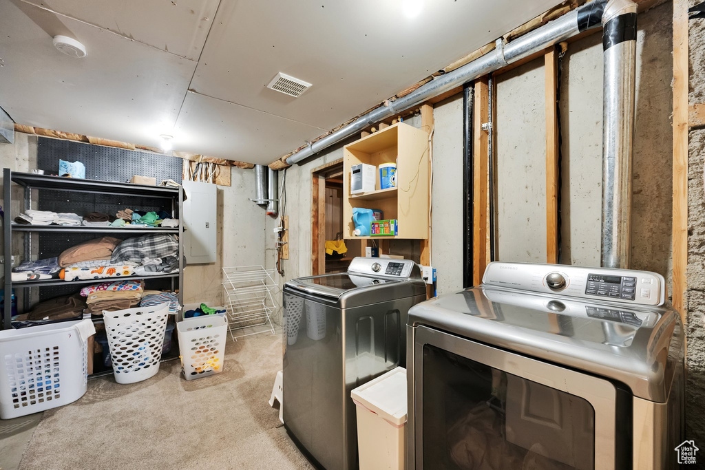 Clothes washing area featuring separate washer and dryer, laundry area, visible vents, and light colored carpet