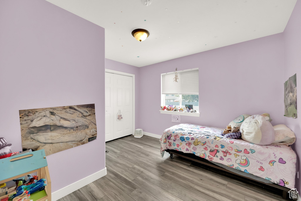 Bedroom with baseboards, a closet, and wood finished floors
