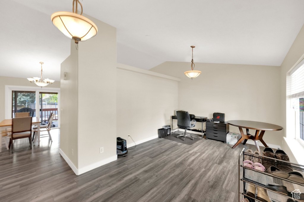Office area with a wealth of natural light, wood finished floors, lofted ceiling, and a notable chandelier