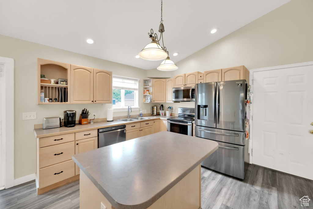 Kitchen featuring open shelves, light brown cabinetry, and appliances with stainless steel finishes