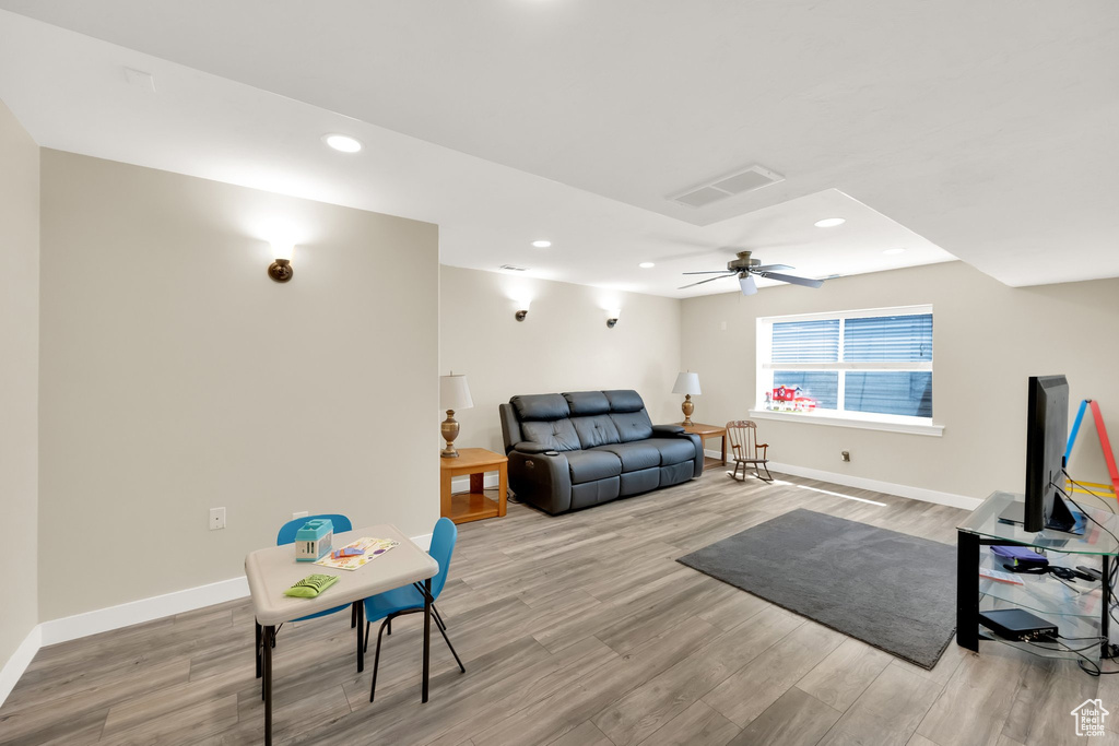 Living area featuring a ceiling fan, recessed lighting, baseboards, visible vents, and wood finished floors