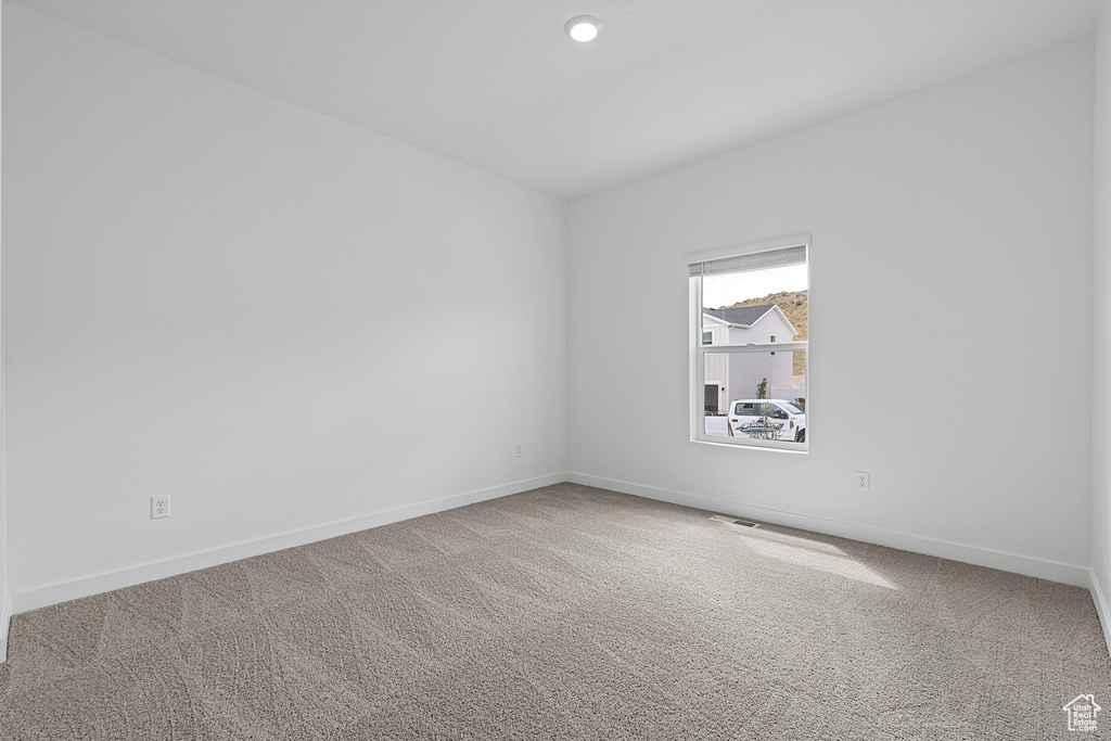 Spare room with carpet flooring, visible vents, baseboards, and recessed lighting