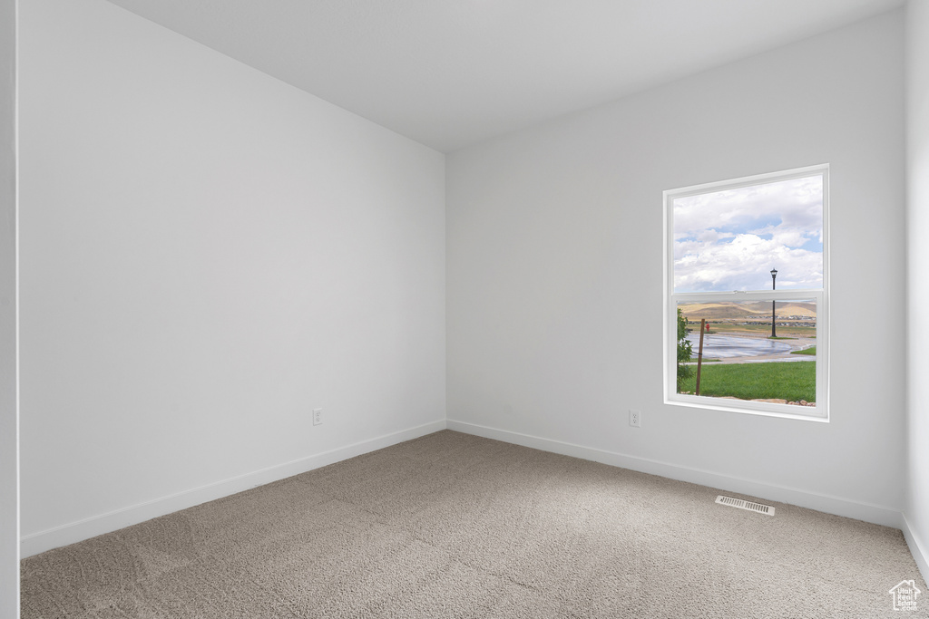 Unfurnished room with visible vents, baseboards, and carpet floors