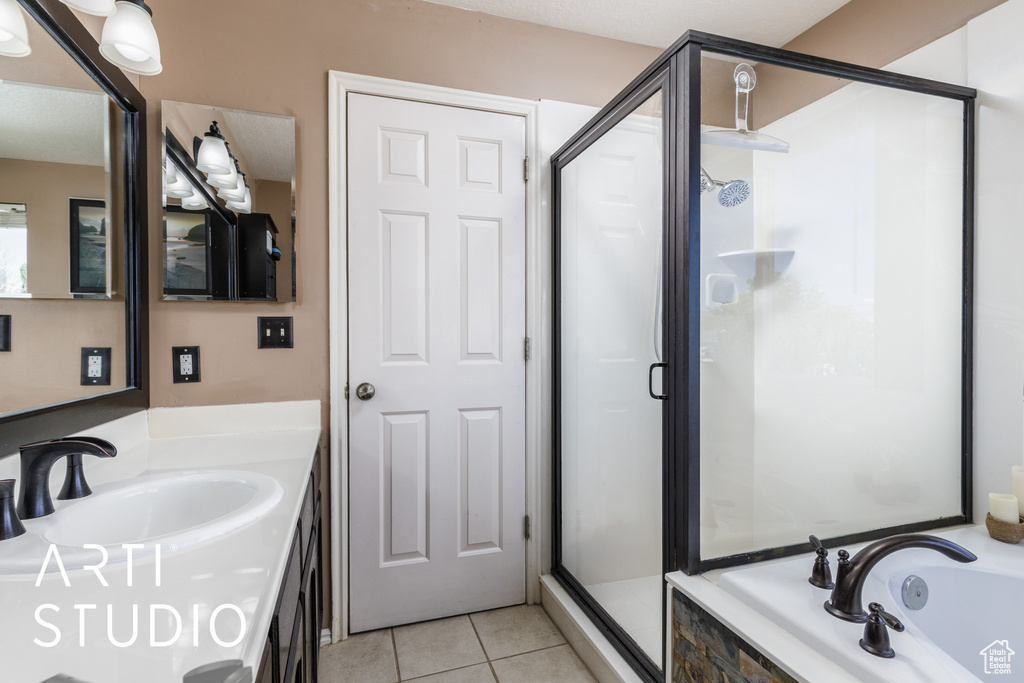 Bathroom featuring a shower stall, tile patterned flooring, vanity, and a bath