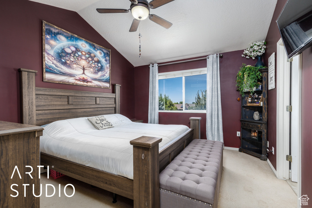 Carpeted bedroom featuring lofted ceiling, baseboards, and a ceiling fan