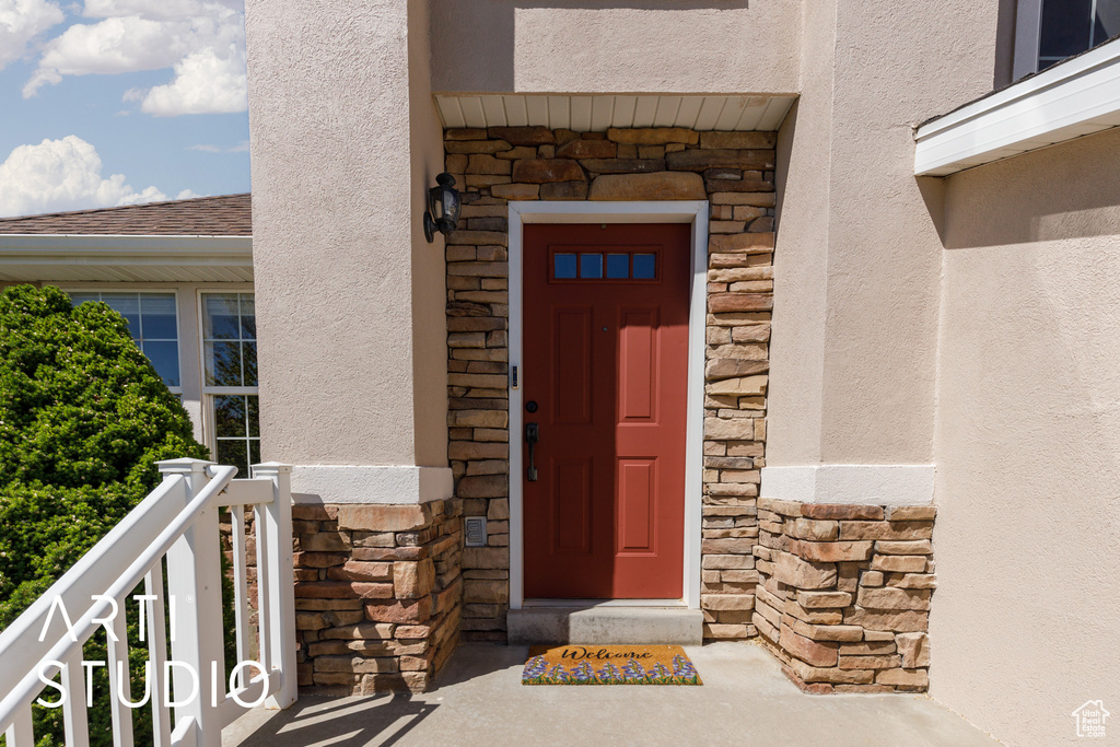 Entrance to property with stone siding and stucco siding