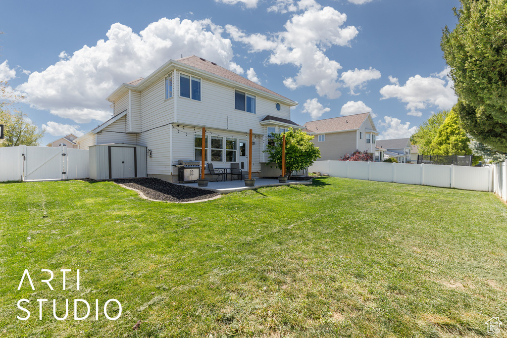 Rear view of house featuring a yard, a patio area, a fenced backyard, and a gate