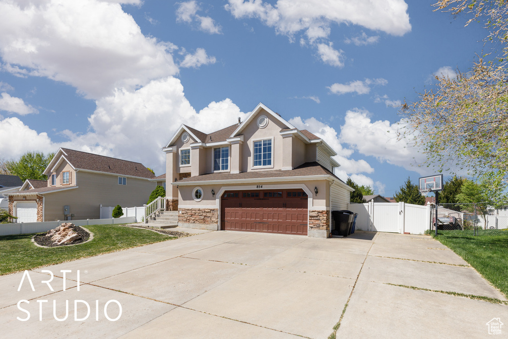 Craftsman-style house with driveway, fence, an attached garage, stucco siding, and a gate