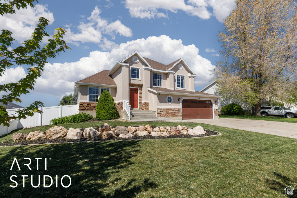 Craftsman-style house featuring fence, an attached garage, stone siding, concrete driveway, and stucco siding