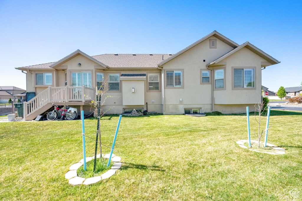 Rear view of property with a yard and stucco siding