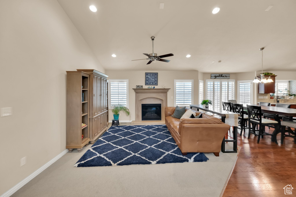 Living room with plenty of natural light, a glass covered fireplace, ceiling fan, and recessed lighting