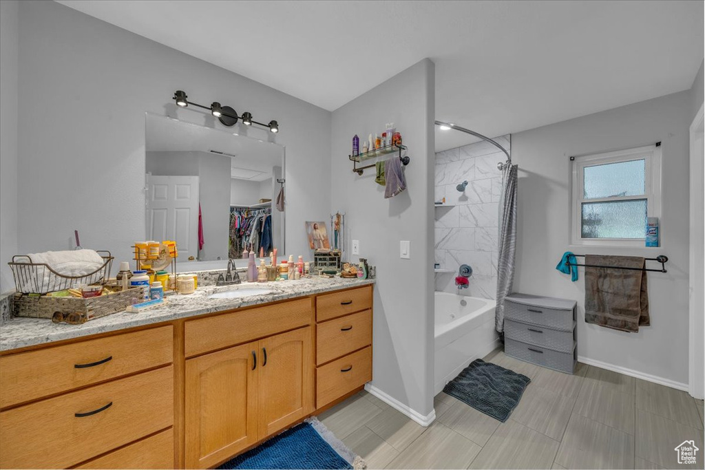 Bathroom with baseboards,  shower combination, and vanity
