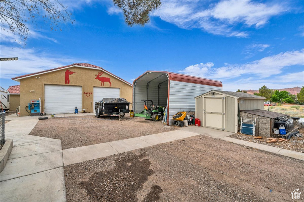 Detached garage with a carport and a storage unit