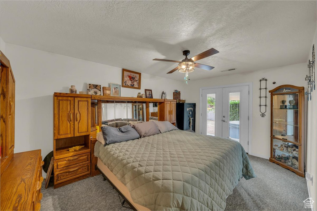 Bedroom featuring carpet flooring, french doors, access to exterior, a textured ceiling, and visible vents