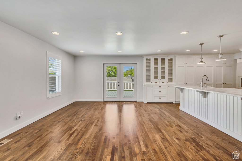 Unfurnished living room featuring baseboards, plenty of natural light, and recessed lighting