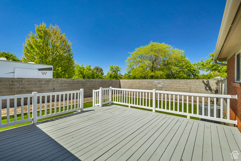 Wooden terrace with a yard and a fenced backyard