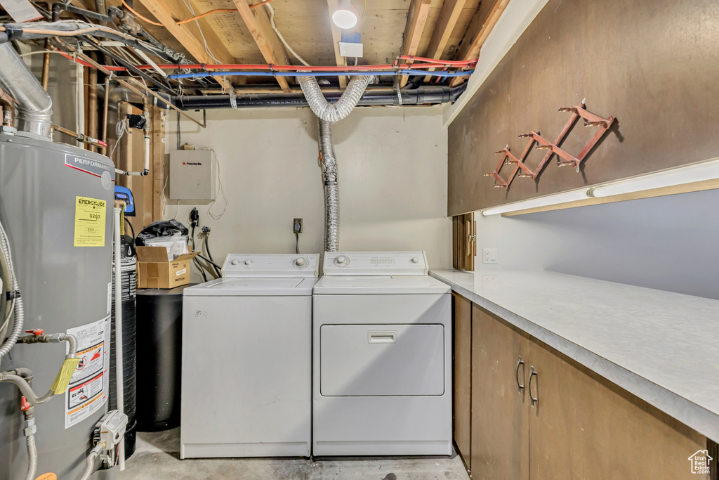 Clothes washing area featuring laundry area, washer and dryer, and gas water heater