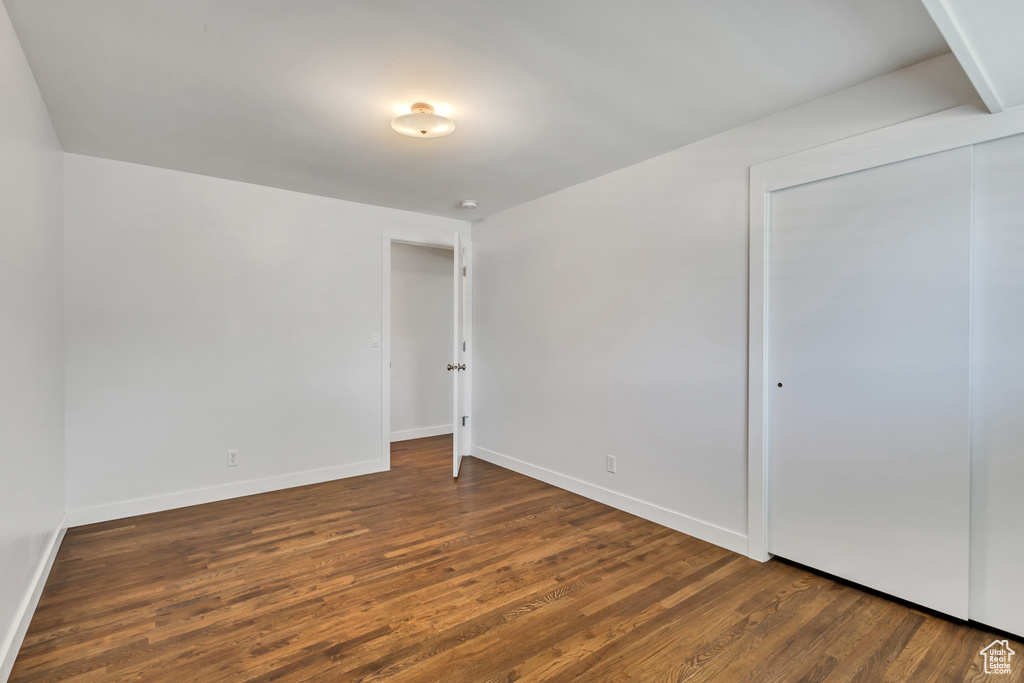Unfurnished bedroom with baseboards, a closet, and wood finished floors