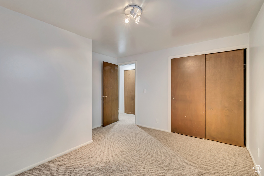 Unfurnished bedroom with baseboards, carpet flooring, and a closet