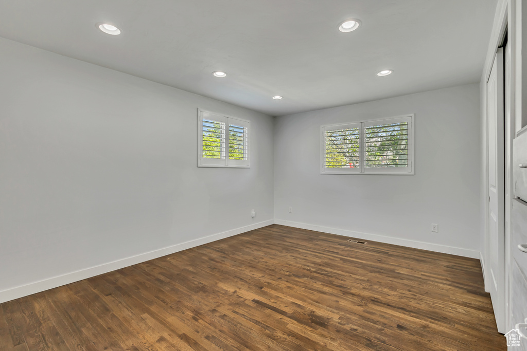 Spare room with baseboards, recessed lighting, and dark wood-style floors