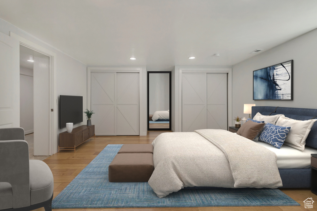 Bedroom with recessed lighting, two closets, visible vents, and light wood-type flooring